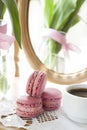 Three pink macaroons and cup of coffee, pink tulips and mirror Royalty Free Stock Photo