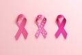 Three pink ribbons isolated on a pink background with copy space for Breast Cancer Awareness Month and World Cancer Day. Flyer, Royalty Free Stock Photo