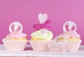 Three pink theme baby girl cupcakes on pink Royalty Free Stock Photo