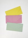 Three pink, yellow and green closed envelopes for money on white background, message concept Royalty Free Stock Photo