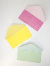 Three pink, yellow and green empty open envelopes for money on white background, message concept Royalty Free Stock Photo