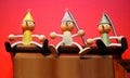 Three Pinocchio wooden puppets on red background