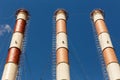 Three pipes of an industrial enterprise against a blue sky Royalty Free Stock Photo