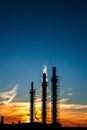 three pipes of a plant on a background of sunset and blue sky. S Royalty Free Stock Photo