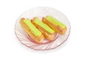 Three pistachio eclairs on the pink glass dish