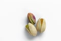 Three pistachio nuts lie on a white background