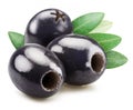 Three pitted black olives with olive leaves isolated on white background Royalty Free Stock Photo