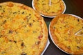 Three pizzas with cheese and mushrooms of different sizes on a dark background Royalty Free Stock Photo