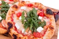 Three pizzas with prawns, tomatoes, arugula and cheese on a wooden background