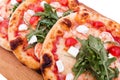 Three pizzas with prawns, tomatoes, arugula and cheese on a wooden background