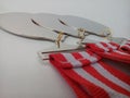 Three plain silver medals with red and white ribbons