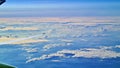 Three planes fly high behind the white clouds and against blue sky Royalty Free Stock Photo