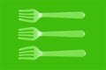 three plastic white forks on a green background. isolate. Top view. Royalty Free Stock Photo