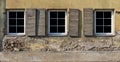 Three plastic white windows in the yellow plastered wall of a Royalty Free Stock Photo