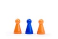 Three playing plastic figures. Two orange and one different blue, isolated on white background Royalty Free Stock Photo