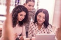 Three pleasant good-looking master students watching video on laptop together