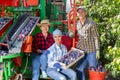 Three plum plantation workers and crop collecting machine Royalty Free Stock Photo