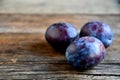 Three plums on old wooden boards. Royalty Free Stock Photo