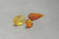 Three polished fire opal gems of different shapes and shades of yellow and orange. Gems and minerals