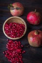 Three red  pomegranate with bowl on real wooden table Royalty Free Stock Photo