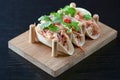 Three pork carnitas street tacos in yellow tortilla with onion, meat, cabbage and parsley on wooden board Royalty Free Stock Photo