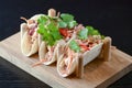 Three pork carnitas street tacos in yellow tortilla with onion, meat, cabbage and parsley on wooden board Royalty Free Stock Photo