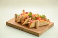 Three pork carnitas street tacos in yellow tortilla with onion, meat, cabbage and parsley on wooden board Royalty Free Stock Photo