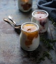 Three portions of fresh natural homemade organic yogurt in a glass jar on a vintage background