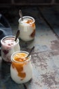 Three portions of fresh natural homemade organic yogurt in a glass jar on a vintage background