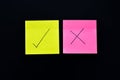 Three post its on black background with a question mark and tick