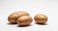 A simple studio shot of three potatoes arranged on a plain white background with soft shadows below Royalty Free Stock Photo