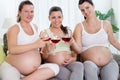 Three pregnant women drinking wine