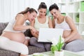 Three pregnant women looking in laptop