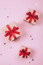 Three presents with red bow on pink