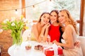 Three pretty, nice, confident, successful girls sitting in restaurant, embracing, having glasses with champagne, wine, alcohol, b