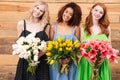 Three pretty women holding bouquets of flowers