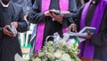 three priests reading prayers from the bible at a funeral to bless the grave Royalty Free Stock Photo