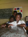 Three primary schoolkids using tablet in classroom.