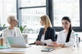 three professional different age businesswomen at meeting