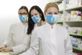Three professional female pharmacists with masks