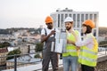 Three project managers inspecting reduced copy of building