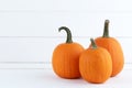 Three pumpkins on white wood Royalty Free Stock Photo