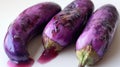 Three Purple Eggplants with Stained Juice on a White Surface Royalty Free Stock Photo
