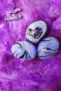 Three purple marbled easter eggs and letters saying Happy Easter in German on purple feathers