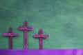 Three purple wooden cross in green background. Holy week and lent season celebration concept. Royalty Free Stock Photo