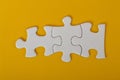 Three puzzle pieces isolated on a yellow background