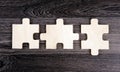 Three puzzle pieces in a row on a wooden background