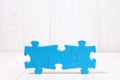 Three puzzle pieces on white wooden background