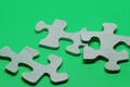 Three puzzle pieces in wood on green background