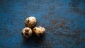 Three Quail eggs on a blue rustic metal bckground